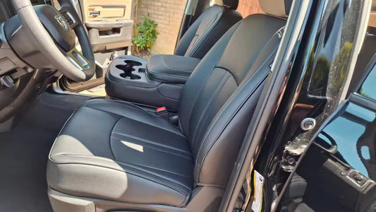 Front seats of RAM 1500 covered in black artificial Nappa leather seat covers with white stitching