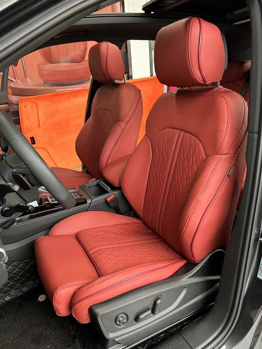 Front seats of Audi A4 covered in red artificial nappa leather with diamond pattern stitching