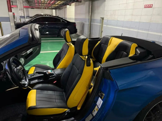 Interior front seats of blue Mustang convertible with custom black and yellow artificial nappa leather seat covers