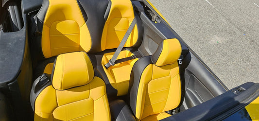 Custom yellow and black seat covers installed in convertible Mustang viewed from above
