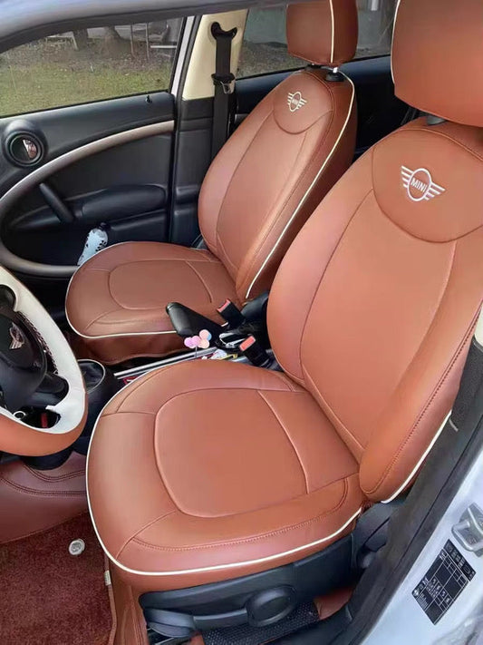 Front seats of Mini Countryman covered in caramel artificial Nappa leather with white piping and Mini logo embroidery on headrests