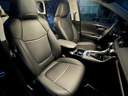 Front seats of 2020 Toyota RAV4 fitted with black artificial Nappa leather seat covers showing detailed stitching and headrest coverage.