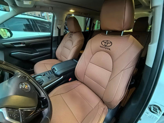 Front seats of Toyota Kluger with brown artificial Nappa leather seat covers and black embroidered Toyota logos on headrests
