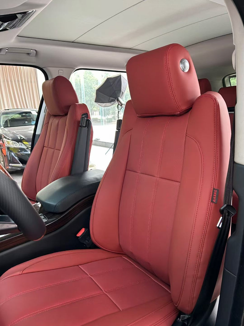Close-up of red artificial Nappa leather front seats in a Land Rover Range Rover with tailored fit and stitching detail