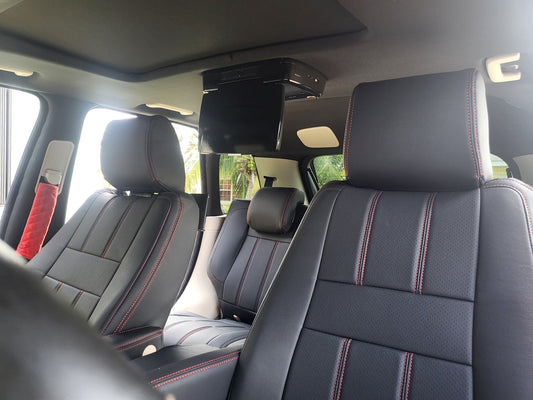 Front seats of Land Rover Range Rover Sport 2010 with black artificial nappa leather seat covers featuring red stitching and red quilted seatbelt covers