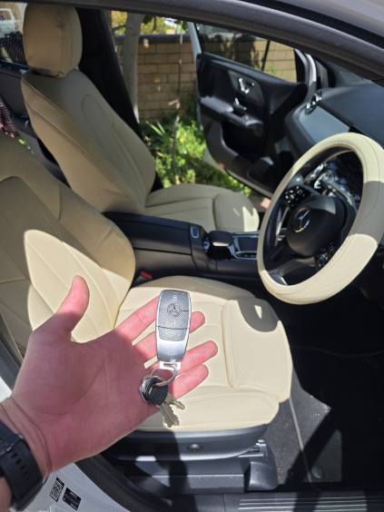 Mercedes Benz 2019 B180 front seats and steering wheel covered in beige artificial Nappa leather with person holding car key