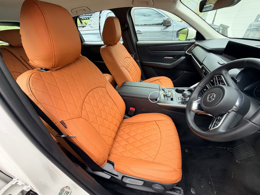 Front seats of Mazda CX-60 2025 with custom caramel colored artificial nappa leather quilted seat covers