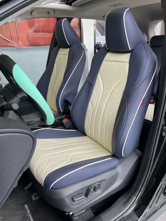 Front custom seat covers in two-tone beige and navy blue artificial Nappa leather on a Toyota Corolla Cross