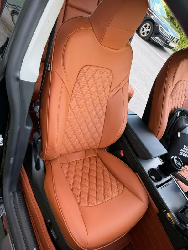 Close-up of Tesla Model Y front seat covered in Cayenne Orange artificial nappa leather with diamond stitching